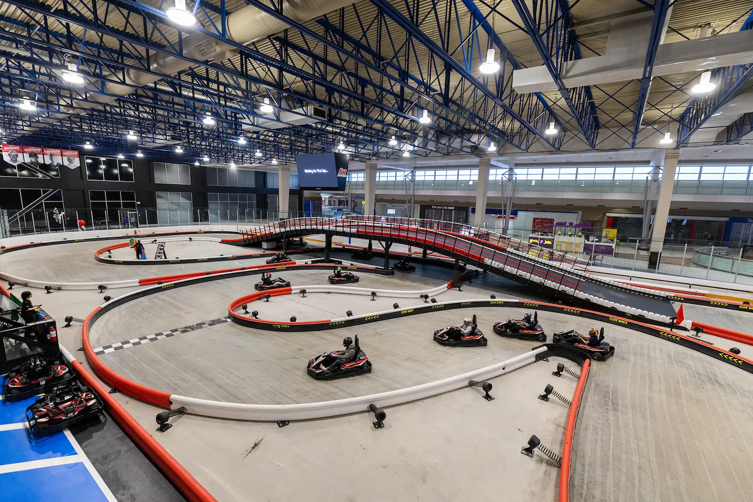 Karting event packages and included amenities for teams Team karting event with multiple drivers racing on an indoor go-kart track