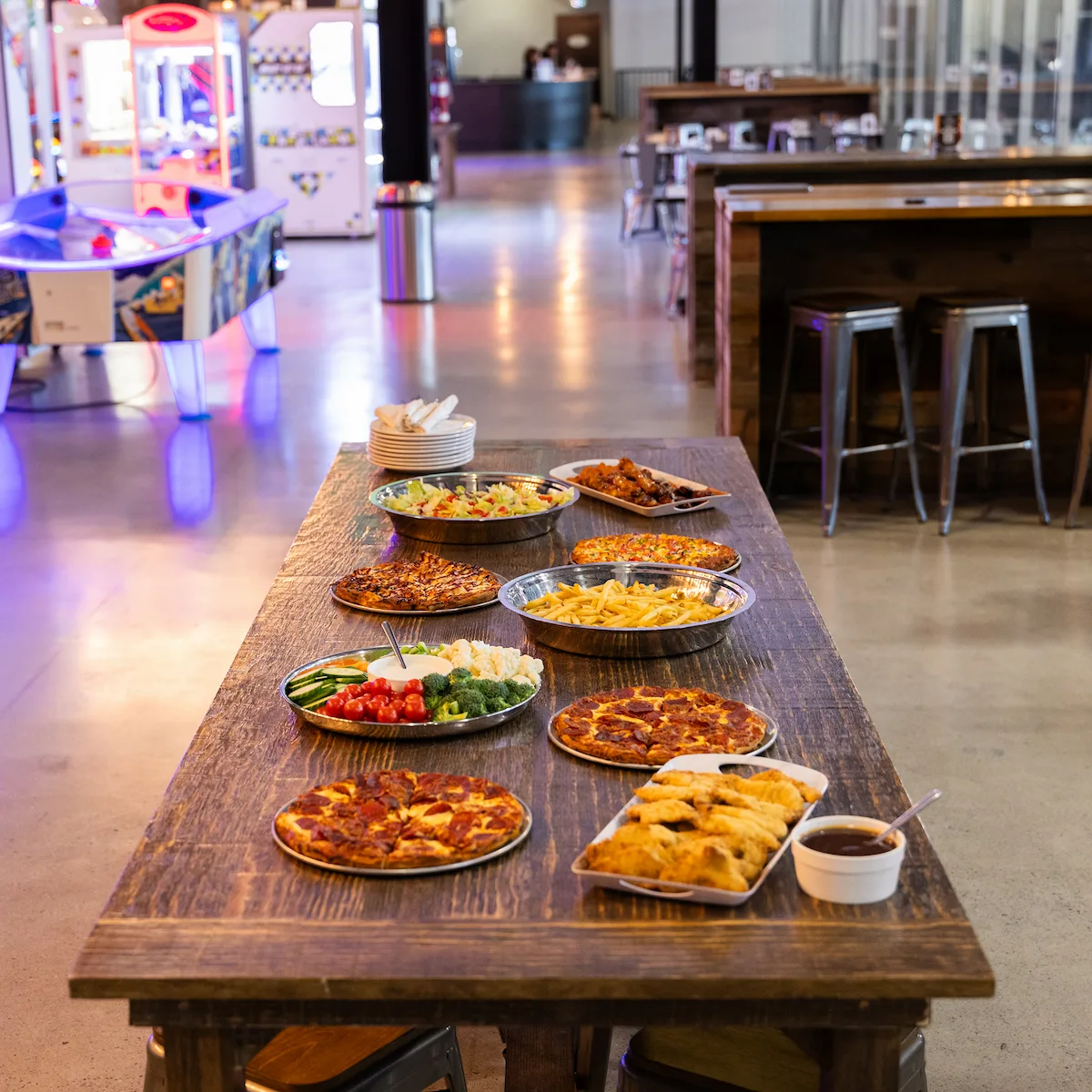 Catering table with pizza, fries, chicken, vegetables, and party food at a go-karting venue