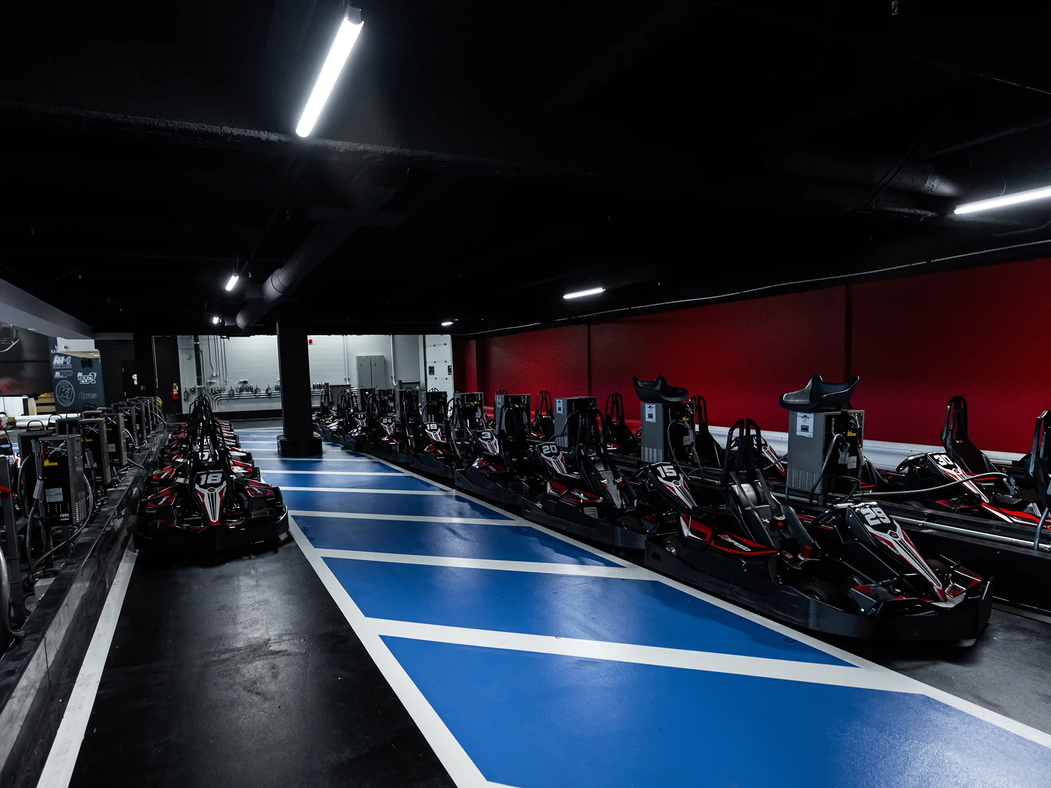 Indoor go-karting track with a row of electric karts ready for group racing