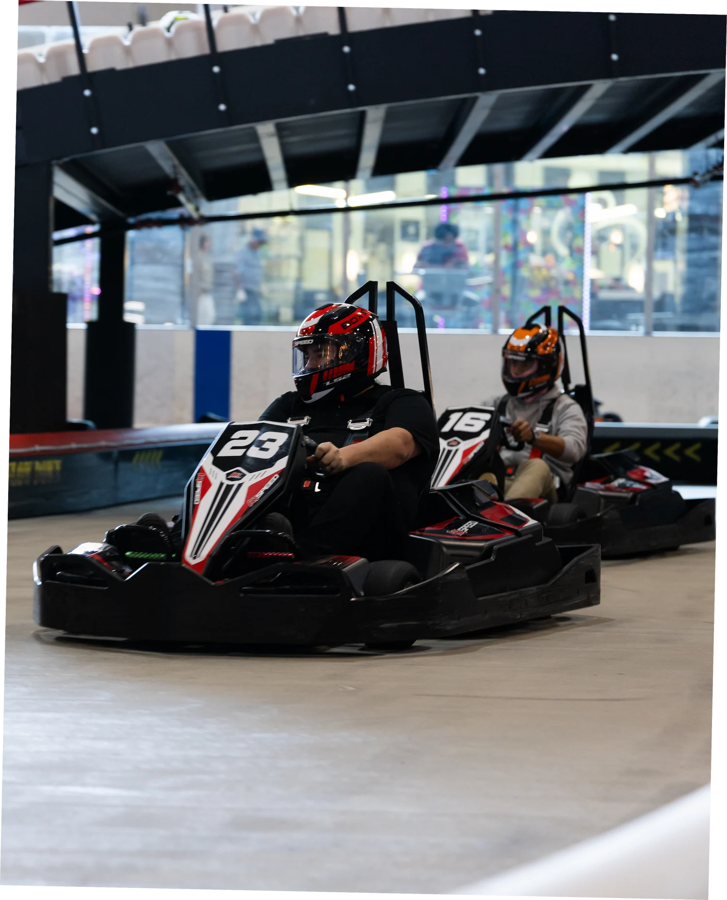 which indoor tracks host corporate events and parties Drivers racing electric go-karts at an indoor corporate event venue